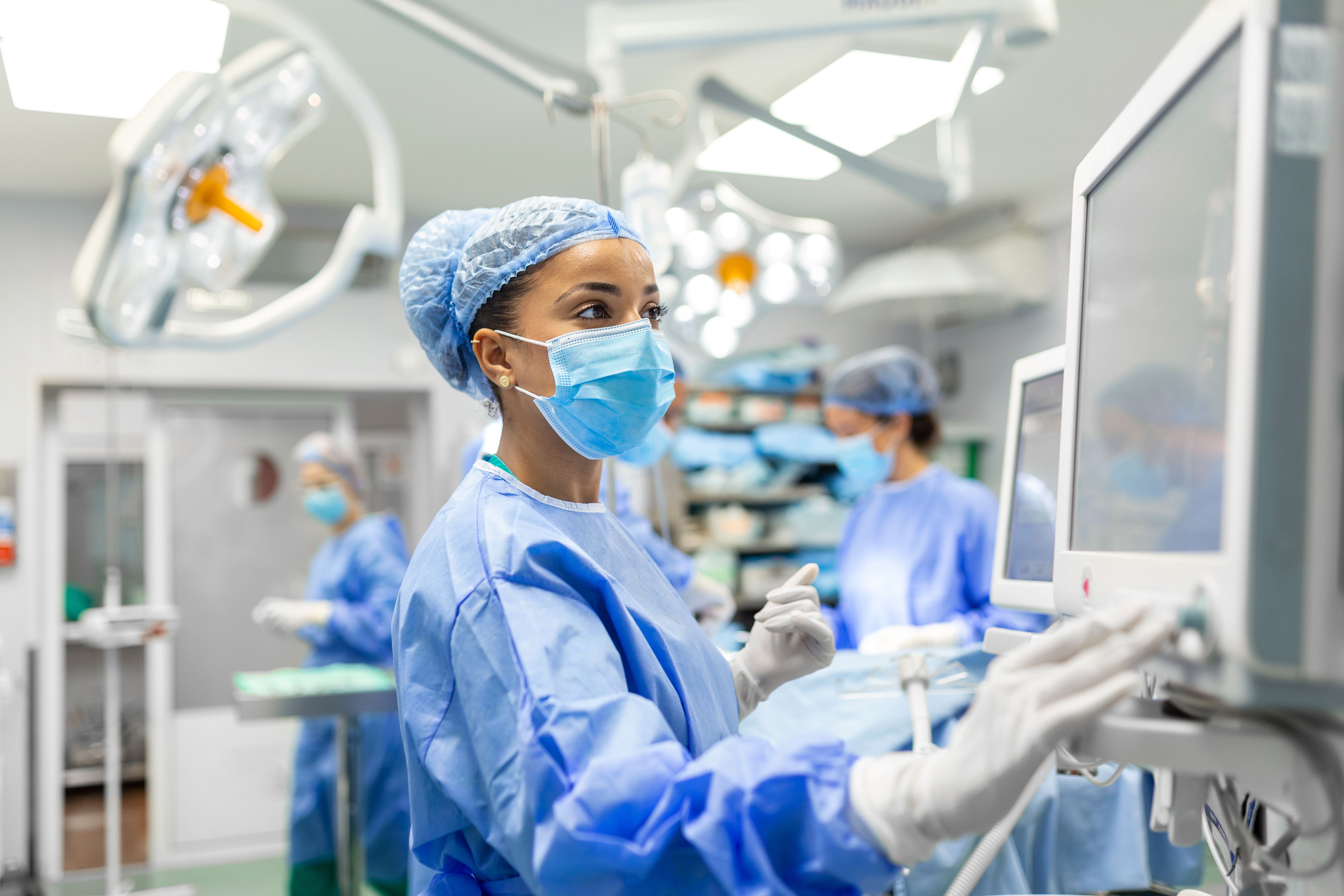 Illustrative photo of a medical assistant at an operating room setting up the equipment.